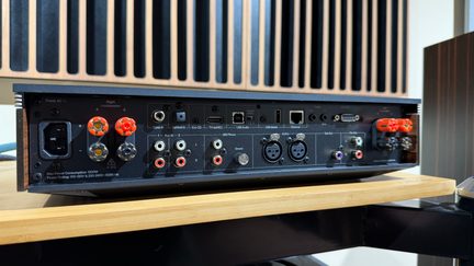 Černý síťový audio zesilovač, pohled zezadu se svorkami pro reproduktory, HDMI ARC, RCA vstupy a Ethernetem