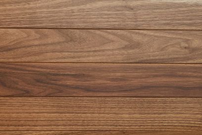 Superficie in doghe orizzontali di legno marrone nocciola a venatura visibile, finitura liscia opaca, vista dall’alto in primo piano