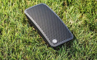Bærbar Audio Pro P5 Bluetooth-højttaler i sort, placeret i græsset, set ovenfra, med det sorte højttalergitter synligt