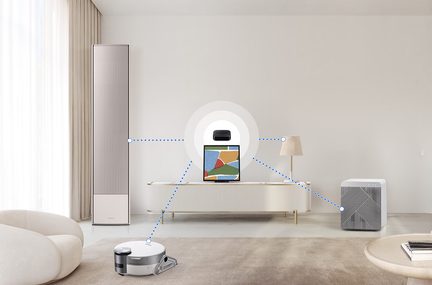 Stue med lyse gardiner, rund lænestol, lavt møbel, lampe, luftrenser, robotstøvsuger, skærm med farvet ramme