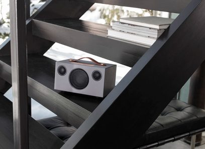 Enceinte Audio Pro ADDON C3 gris sur étagère en bois foncé, vue de face, avec livres empilés à côté