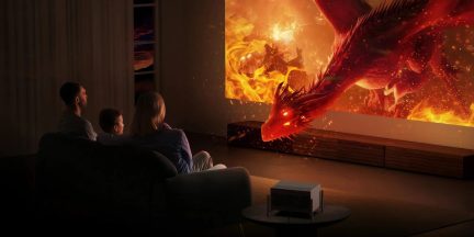 Videoproiettore compatto che proietta un drago rosso in fiamme in un soggiorno familiare buio