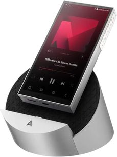 Odtwarzacz audiofilski Astell&Kern PD10 w srebrnym aluminium, z czarnym, podświetlonym ekranem dotykowym, bocznymi grawerowanymi przyciskami, prezentowany w skośnym ujęciu na dopasowanej, okrągłej podstawce z szczotkowanego metalu i czarnej, teksturowanej powierzchni gumowej