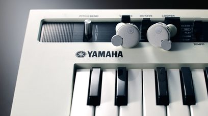 Yamaha elektronisk keyboard med sorte og hvide tangenter, kontrolknapper og Yamaha-logo på den hvide front