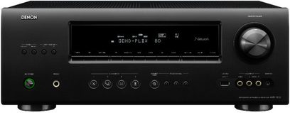 Denon AVR-1912 sort hjemmebiografsforstærker, set forfra, blå skærm, sølvfarvede knapper og drejeknapper, hovedtelefonstik til højre