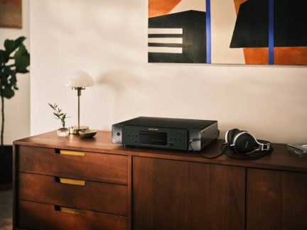 Must Marantz CD 50n võrguga CD-mängija, asetatud puhvetkapile koos juhtmega kõrvaklappidega