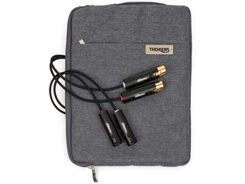 Widok z góry na kabel phono Thorens PhonoConnect PHS 150 XLR-XLR 1,5 m, czarny z oplotem, cztery czarne metalowe wtyki ze złoconymi końcówkami i pierścieniami w kolorze czerwonym i srebrnym, ułożony na antracytowej tekstylnej saszetce z tabliczką Thorens.