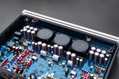 Sidabrinis garso keitiklis DAC RD160, vaizdas iš viršaus, elektroniniai komponentai, cilindriniai kondensatoriai, mėlyna plokštė