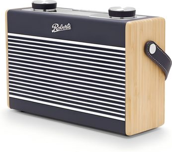 Rádio Roberts Rambler Max v tmavě modrém provedení s horizontálně žebrovaným předním panelem v bílé a modré barvě, světlými dřevěnými boky, dvěma kovovými otočnými knoflíky na horní straně, bočním koženým řemínkem v tmavě modré barvě se stříbrným nýtem, pohled z pravého předního tříčtvrtečního úhlu.