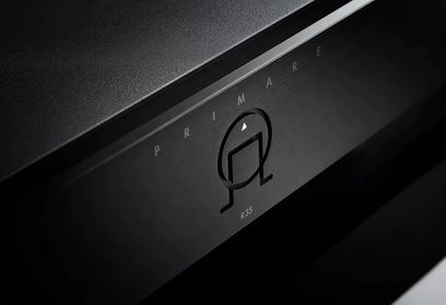Primare R35 preto, pré-amplificador estéreo, vista frontal aproximada do logotipo e do botão de volume em alumínio escovado