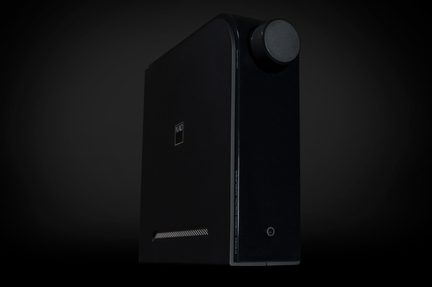 Amplificator NAD negru mat din metal, vedere în diagonală, buton de volum, mufă pentru căști pe fațadă, grilă laterală