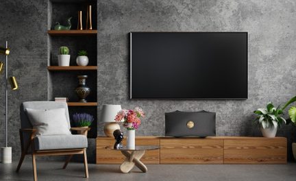 Mobile TV basso in legno chiaro con televisore a schermo piatto a parete, decorazione soggiorno moderna con parete in cemento grigio