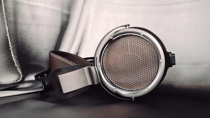 Cuffia hi-fi aperta STAX SR-X9000 argentata, vista ravvicinata del profilo destro, griglia metallica sull'auricolare, archetto in pelle