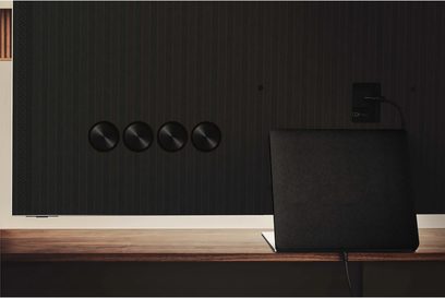 Televizor Samsung QE55QN95B 2022 černý, pohled zepředu, 4 kulatá tlačítka na pravé straně, umístěný na dřevěném nábytku