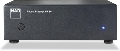 NAD PP2e anthracite grijze phono-voorversterker in mat metalen behuizing, vooraanzicht, met zwarte ronde knop aan de linkerkant, wit logo en opschrift, blauwe LED aan de rechterkant, rustend op twee cilindrische voetjes