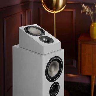Boxă de podea hi-fi albă cu modul Dolby Atmos înclinat, woofere circulare, într-un living cu design contemporan