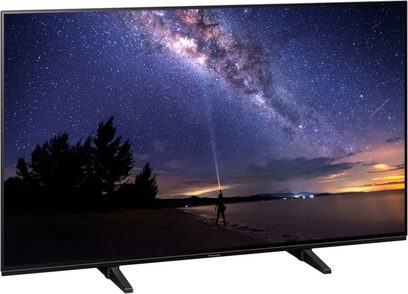 Panasonic TX-48JZ1000E-tv, der viser et natligt landskab med stjernebestrøet himmel, Mælkevejen og en menneskelig silhuet på en strand ved en sø