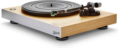 Giradischi hi-fi Roberts Stylus Luxe in legno chiaro con frontale in alluminio spazzolato argentato, piatto circolare nero, braccio di lettura metallico e pulsante di accensione, vista prospettica anteriore sinistra