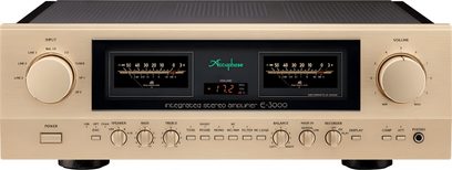 Accuphase E-3000 integrerad stereo hi-fi-förstärkare i champagnefärgad aluminium, sedd framifrån, rektangulär front med svart mittpanel och två bakgrundsbelysta VU-mätare, stora runda reglage för ingångsval och volym på sidorna, nedre rad med knappar och potentiometrar