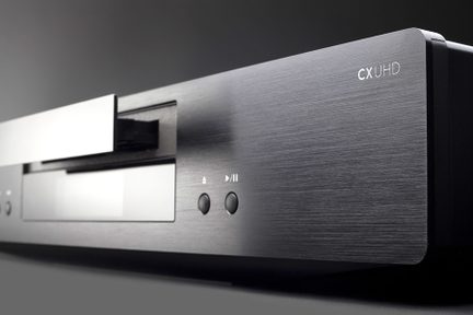 Lecteur Blu-ray CX UHD en métal brossé, vue de face rapprochée, avec deux boutons et un voyant lumineux