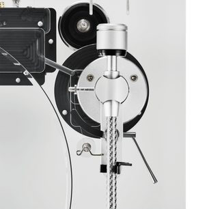 Nærbillede set ovenfra af Audio Technica AT-LPA2 hi-fi pladespiller i sølvfarvet metal, sort plast og transparent akryl, med detaljer af den cirkulære armpivot, det cylindriske modvægt og den flettede kabel