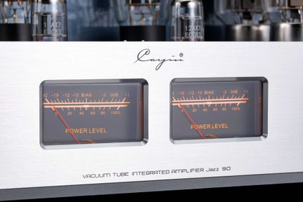Front af en rørforstærker i børstet aluminium, set forfra, to orange analoge VU-metre med røde visere