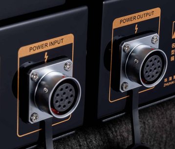 Černý sluchátkový předzesilovač Cayin HA-6A MK2, detailní záběr, dva kovové kruhové vícepinové konektory Power Input/Output