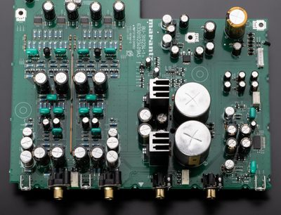 Must ja sisemine Marantz SACD 30n elektroonikaplaat, vaade ülalt koos silindriliste kondensaatorite ja kullatud RCA-pistikupesadega