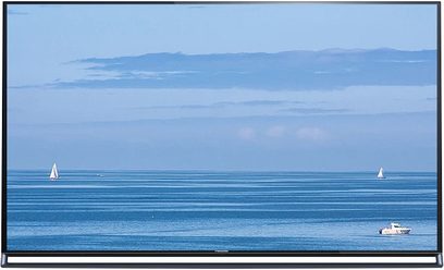 Panasonic TX-55AS800E-fladskærm, der viser et roligt havudsigt med to sejlbåde i det fjerne under en klar blå himmel