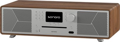 Alt-i-en hi-fi-system Sonoro Meisterstück (gen 2) valnød - sølv, set forfra, centralskærm, knapper og drejeknap til venstre, ventilationsåbninger med geometriske mønstre på begge sider, sølvfødder