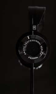 Åben hi-fi hovedtelefon Grado PS2000e sort, tæt profilvisning fra højre side på sort baggrund, sølvfarvet R-logo på ørepude