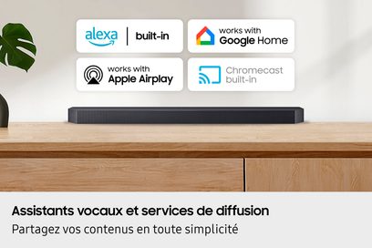 Mattschwarze Soundbar mit feinem Metallgitter an der Front, schlanker rechteckiger Korpus, frontal abgebildet, auf einem Sideboard aus hellem Holz platziert