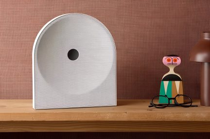 Diffusore di design bianco con frontale arcuato, griglia in tessuto e apertura centrale nera, vista frontale