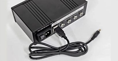 Samostatné černé napájení Nuprime SiGa Power75, pohled zezadu, s DC výstupy, USB portem a napájecím kabelem