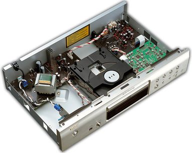 Sølvfarvet Denon DCD-700AE CD-afspiller, set indefra ovenfra, låget åbent, elektroniske og mekaniske komponenter synlige