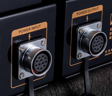 Černý sluchátkový předzesilovač Cayin HA-6A MK2, detailní záběr, dva kovové kruhové vícepinové konektory Power Input/Output