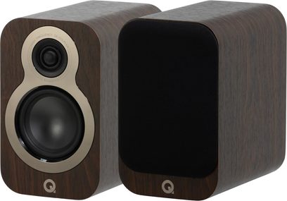 Dvě knihovnové reproduktory Q Acoustics 3010c v provedení ořech, obdélníkový kryt s dýhou hnědého dřeva a zaoblenými hranami zobrazený z tříčtvrtečního pohledu zepředu, jeden s kovovým lemováním tweeteru a wooferu v béžové barvě, druhý s černou akustickou mřížkou