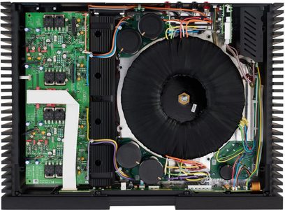 Widok wnętrza otwartego wzmacniacza audio Naim NAP 250, pokazujący zielone płytki drukowane, elektroniczne komponenty i kolorowe okablowanie