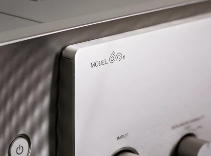 Pogled od blizu na sprednjo ploščo srebrne avdio naprave, besedilo "MODEL 60n", okrogli gumb za vklop/izklop, vrtljivi gumbi