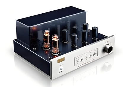Audioförstärkare med rör i svartlackerad metall och borstad silverfärgad aluminium, sedd snett framifrån höger, med fyra glödande vakuumrör på ovansidan, sex svarta cylindrar i rad, en stor ratt och tryckknappar på frontpanelen