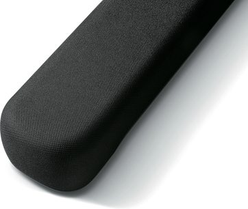 Sort cylindrisk soundbar med tekstureret overflade med små perforeringer over hele, set i nærbillede fra en vinkel