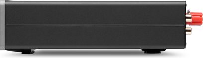 Vista laterale destra di un amplificatore di potenza hi-fi Cambridge Audio MXW70 in metallo nero opaco, corpo rettangolare compatto su piedini con linea di separazione orizzontale e connettori rossi e dorati visibili sul retro