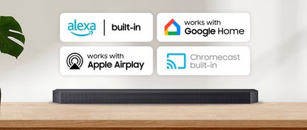 Mattschwarze Soundbar mit perforiertem Frontgitter und abgeschrägten Kanten, von vorne gesehen, auf einer hellen Holzplatte platziert