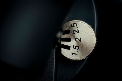 Pro-Ject T2 W noyer yüksek kaliteli plak çalar, üzerinde "1.5", "2", "2.5" kazınmış metalik dairesel bir denge ağırlığının yakın çekimi