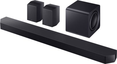 Schwarze Samsung HW‑Q995F Soundbar aus Metallgitter und Kunststoff, dreiviertel Ansicht, lange gerippte Fronteinheit mit würfelförmigem Subwoofer mit seitlichem Lautsprecher und zwei kompakten, mit Gitter versehenen Rücklautsprechern