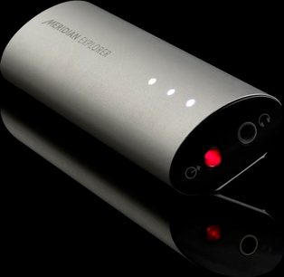 Meridian Explorer sølvfarvet, cylindrisk audio-DAC-konverter med to røde LED'er på en sort, reflekterende overflade