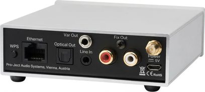 Stream Box S2, vista trasera, carcasa rectangular con acabado claro, conectores negros y metálicos, puertos Ethernet, óptico, RCA, alimentación USB-C