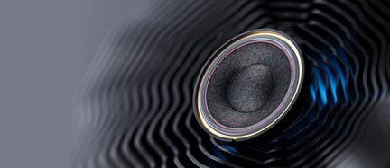 Membrana di altoparlante circolare in tessuto grigio antracite, circondata da un anello metallico dorato e da una sottile sospensione rosata, vista dall’alto in diagonale su sfondo nero ondulato