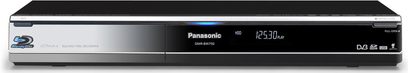 Černý Blu-ray rekordér Panasonic DMR-BW750, pohled zepředu, položený naplocho, na displeji svítí modrý digitální čas "12:30"