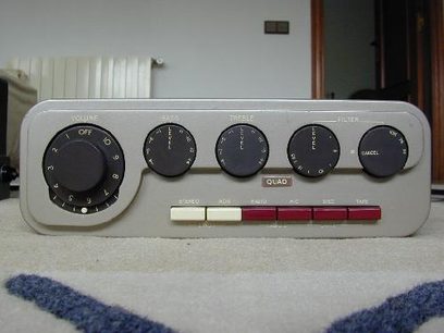 Stara, kultowa konsola audio Quad z czarnymi pokrętłami obrotowymi, białymi i czerwonymi przełącznikami na jasno szarej obudowie